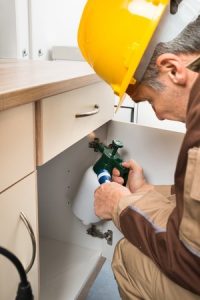 Spraying under a cabinet for general pest control